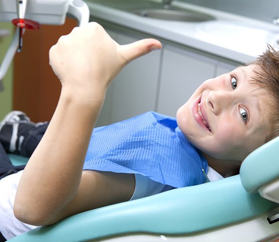 Young boy giving thumbs up during appointment for Phase 1 orthodontics in Channahon, IL