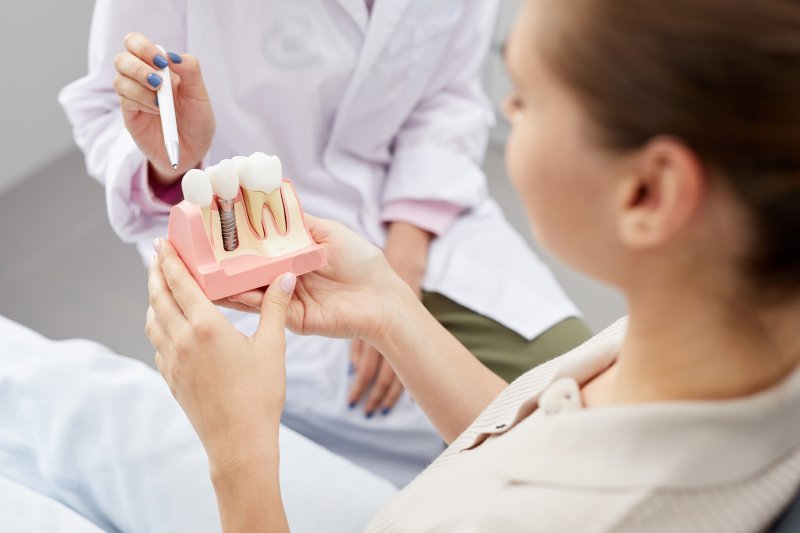 woman looking at a dental implant